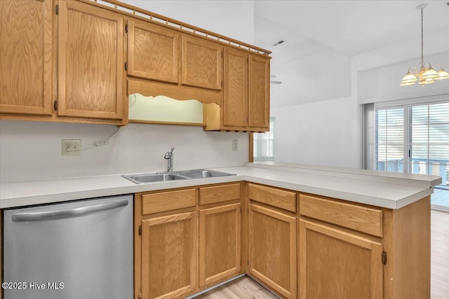 kitchen featuring light countertops, a sink, a peninsula, and stainless steel dishwasher