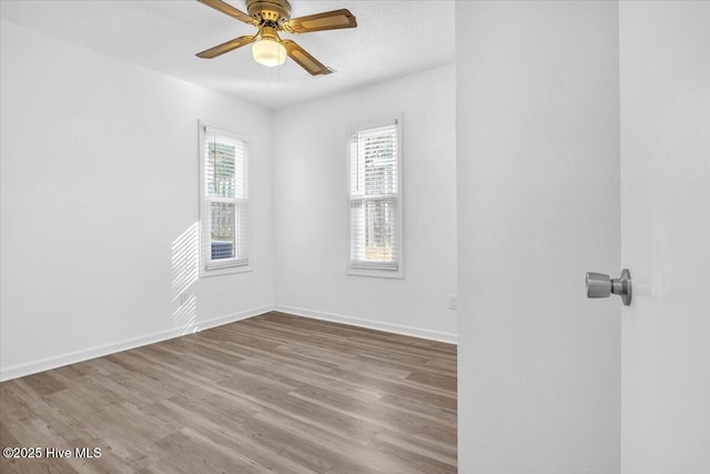 spare room featuring ceiling fan, a textured ceiling, baseboards, and wood finished floors