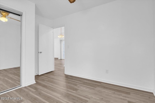 unfurnished bedroom featuring a closet, baseboards, and wood finished floors