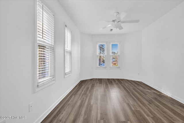 empty room featuring a ceiling fan, baseboards, and wood finished floors