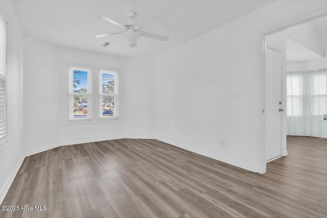 spare room with visible vents, plenty of natural light, and wood finished floors