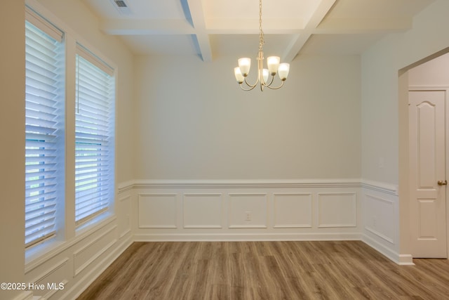 unfurnished dining area featuring a notable chandelier, light wood-style flooring, visible vents, and beam ceiling