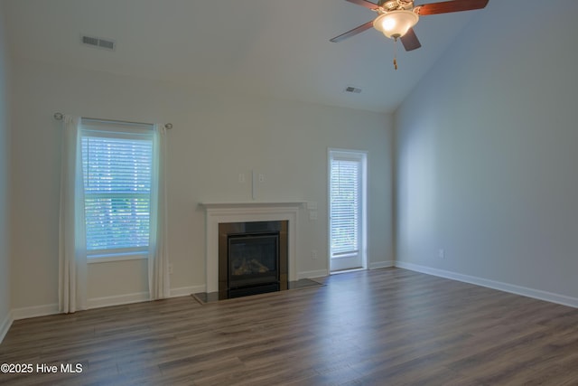 unfurnished living room featuring dark wood-style flooring, a fireplace with flush hearth, visible vents, and a ceiling fan