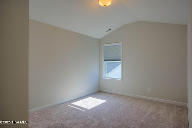 unfurnished room featuring light carpet, baseboards, and lofted ceiling