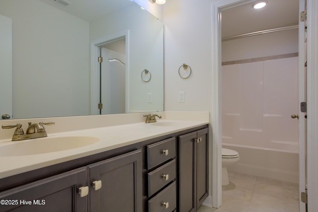 bathroom featuring double vanity, a sink, toilet, and tile patterned floors