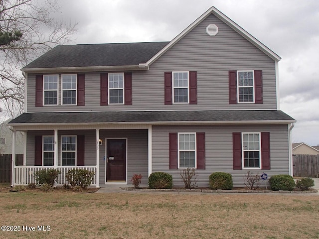 view of front of home with a front yard, fence, and covered porch