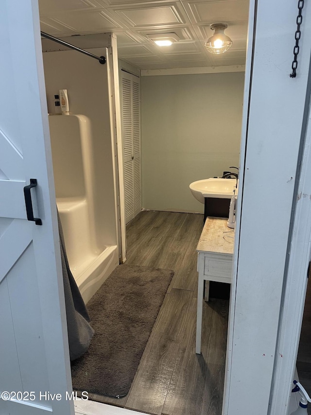 full bathroom with an ornate ceiling, a shower, a closet, vanity, and wood finished floors