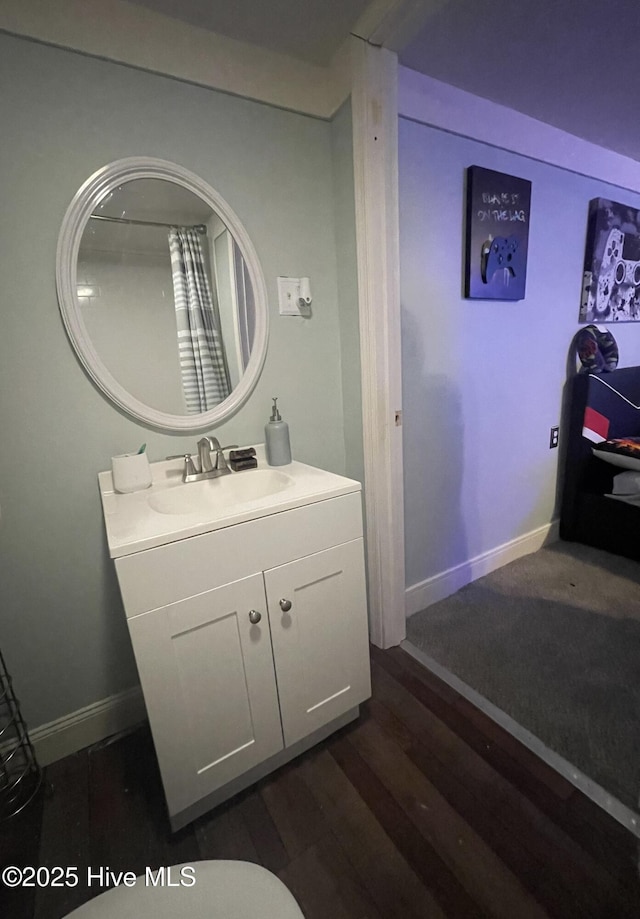 bathroom featuring wood finished floors, vanity, and baseboards