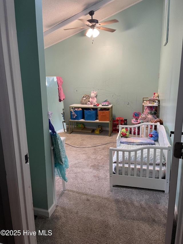 bedroom featuring lofted ceiling, a textured ceiling, baseboards, a nursery area, and carpet