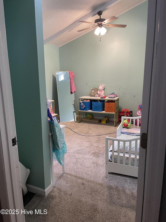 bedroom with a textured ceiling, vaulted ceiling, carpet flooring, and baseboards