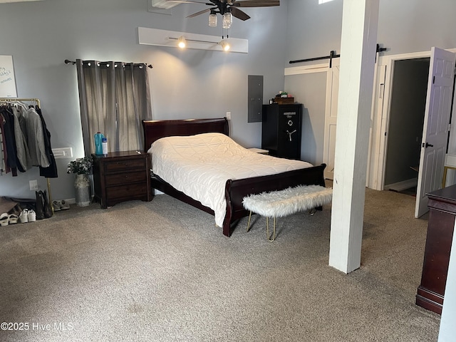 bedroom featuring a towering ceiling, a barn door, electric panel, and carpet flooring