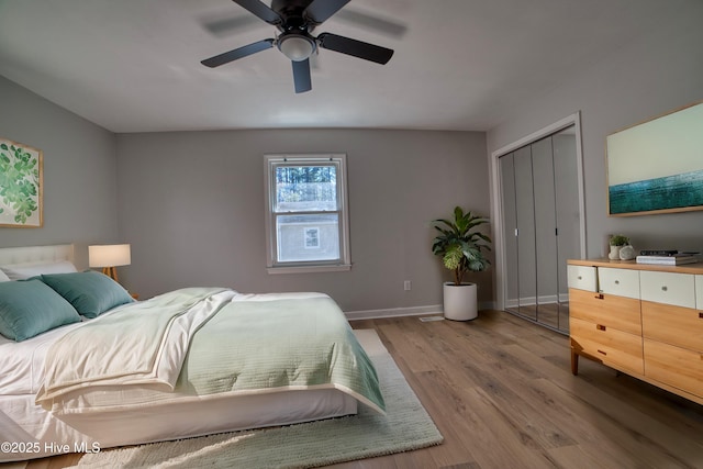 bedroom with a ceiling fan, light wood-type flooring, a closet, and baseboards