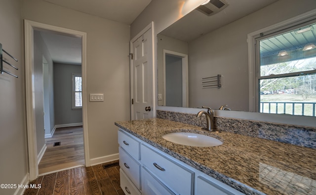 bathroom with vanity, wood finished floors, visible vents, and baseboards