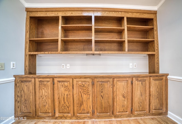 interior details with ornamental molding, baseboards, and wood finished floors