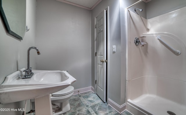 bathroom with crown molding, a stall shower, toilet, and baseboards