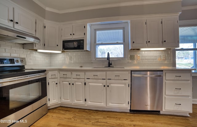 kitchen with stainless steel appliances, white cabinetry, and under cabinet range hood