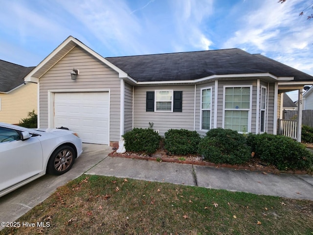 view of front of home with driveway, roof with shingles, and an attached garage