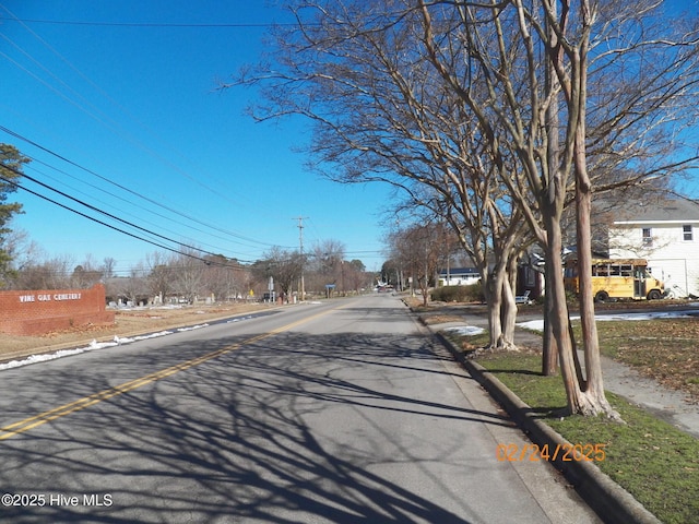 view of road featuring a residential view and curbs