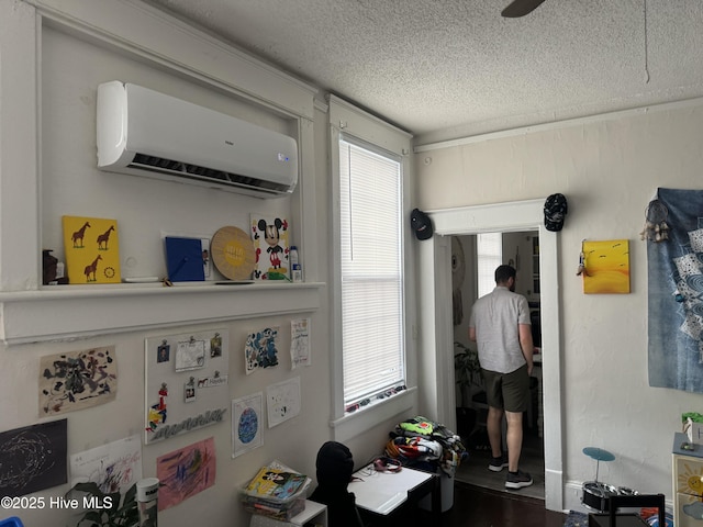 interior space featuring a wall mounted air conditioner and a textured ceiling