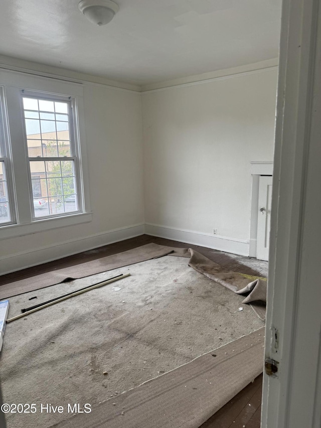 empty room featuring ornamental molding and baseboards