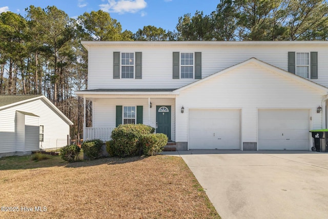 traditional-style house featuring a garage, driveway, a front lawn, and a porch