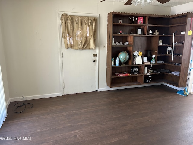 unfurnished room with dark wood-style floors, baseboards, and a ceiling fan