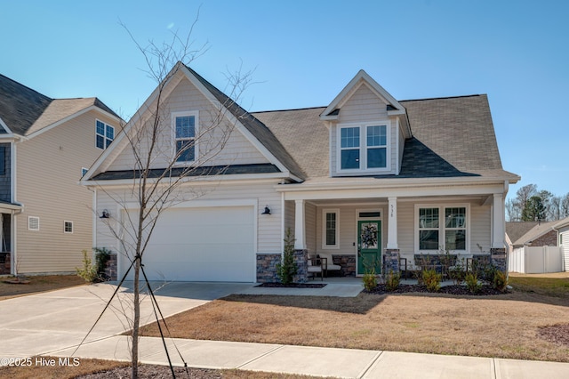 craftsman-style house with stone siding, fence, a porch, and concrete driveway