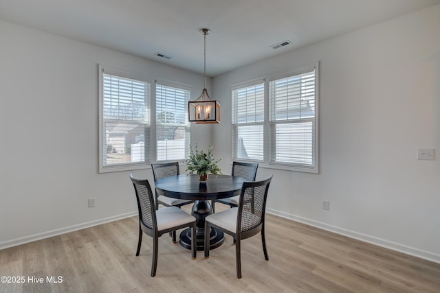 dining area with baseboards, visible vents, and light wood-style floors