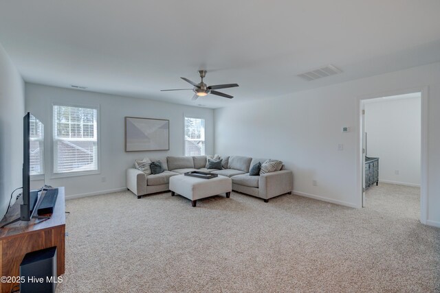 carpeted living area with baseboards, visible vents, and a ceiling fan