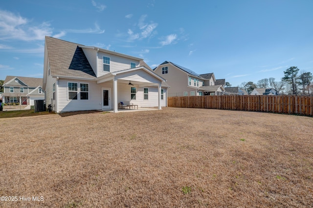 rear view of house featuring a lawn, central AC, a patio area, ceiling fan, and fence