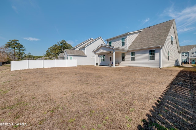 back of property with a ceiling fan, fence, a patio, and a lawn