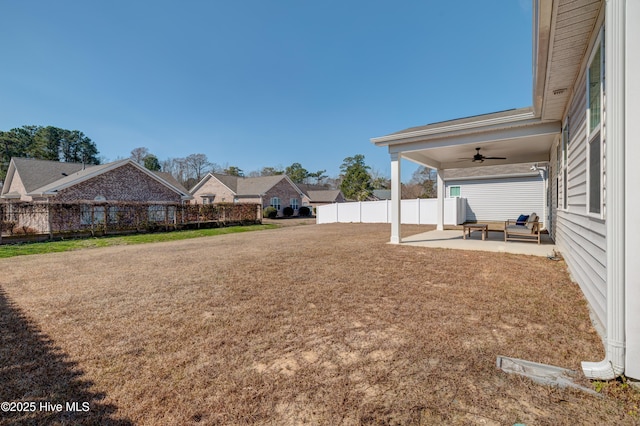 view of yard featuring fence, a ceiling fan, and a patio