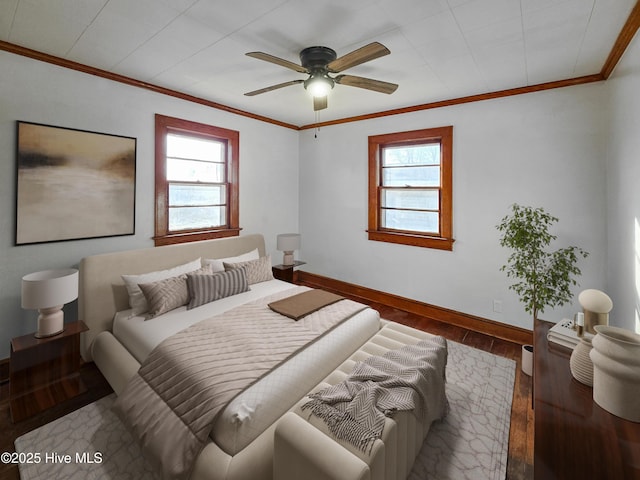 bedroom with multiple windows, baseboards, crown molding, and wood finished floors