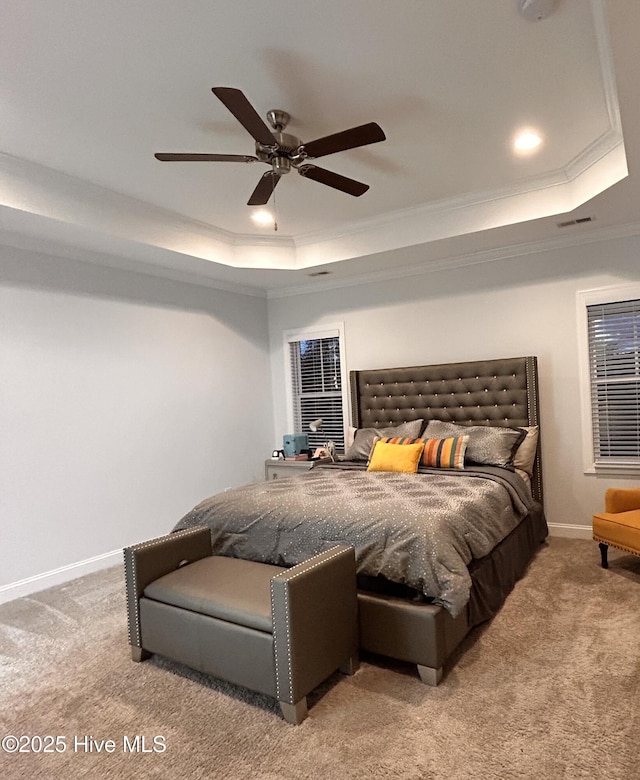 bedroom featuring a tray ceiling, light colored carpet, crown molding, and baseboards