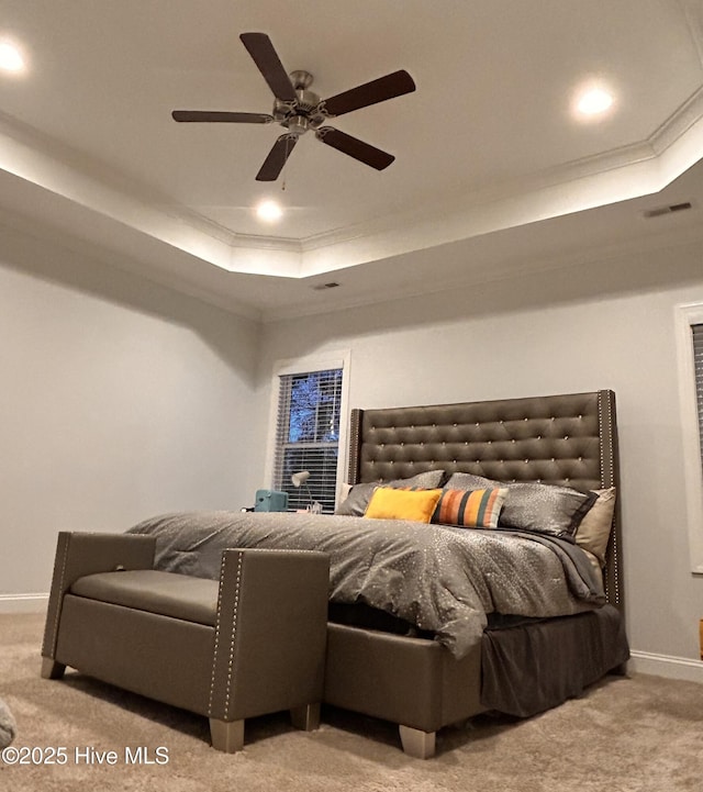 bedroom featuring light carpet, ornamental molding, and a raised ceiling