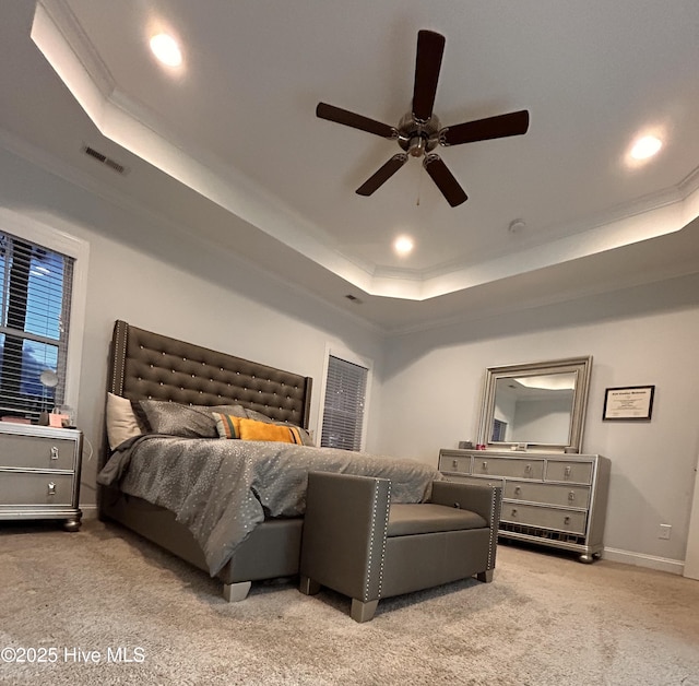 carpeted bedroom featuring recessed lighting, a raised ceiling, visible vents, ornamental molding, and baseboards