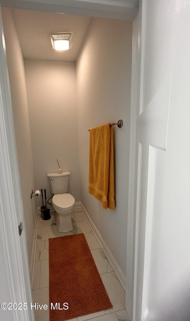 bathroom featuring toilet and baseboards