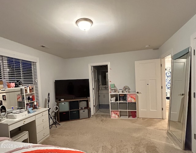 bedroom featuring light carpet, connected bathroom, and visible vents