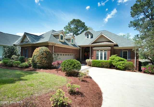 155 Abbington Pl SW, Ocean Isle Beach, NC 28469 - view of front of home featuring brick siding, a garage, driveway, a front yard, and roof with shingles