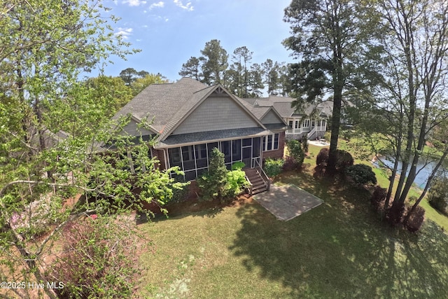 155 Abbington Pl SW, Ocean Isle Beach, NC 28469 - back of house with a sunroom, roof with shingles, and a yard