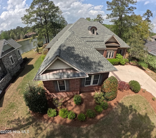 155 Abbington Pl SW, Ocean Isle Beach, NC 28469 - view of front of property featuring roof with shingles, brick siding, a water view, and a standing seam roof