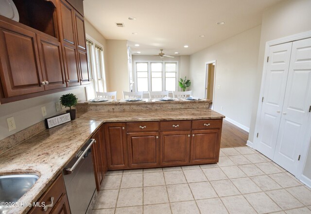 155 Abbington Pl SW, Ocean Isle Beach, NC 28469 - kitchen with dishwasher, a peninsula, a ceiling fan, light stone counters, and a sink