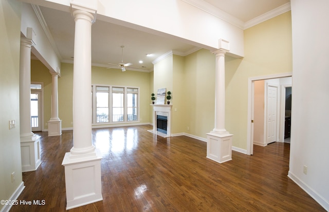 155 Abbington Pl SW, Ocean Isle Beach, NC 28469 - unfurnished living room featuring ceiling fan, dark wood-style floors, a fireplace with flush hearth, ornamental molding, and decorative columns