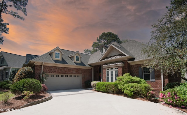 155 Abbington Pl SW, Ocean Isle Beach, NC 28469 - view of front of house featuring brick siding, an attached garage, driveway, and a shingled roof