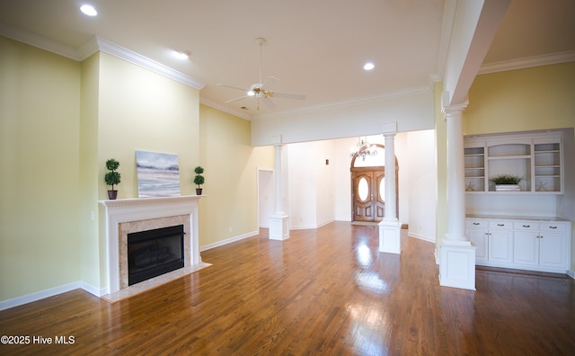 155 Abbington Pl SW, Ocean Isle Beach, NC 28469 - unfurnished living room featuring a ceiling fan, a premium fireplace, dark wood finished floors, ornate columns, and crown molding