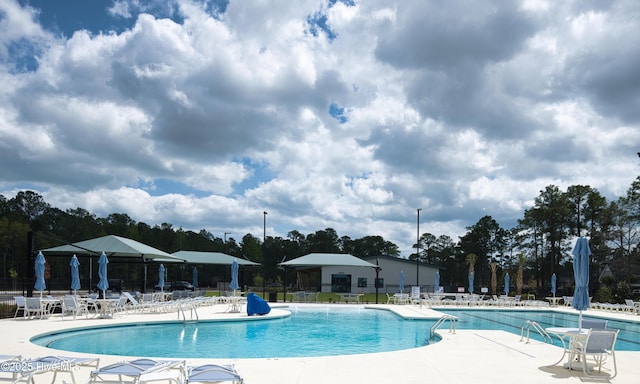 155 Abbington Pl SW, Ocean Isle Beach, NC 28469 - community pool featuring a patio, fence, and view of scattered trees