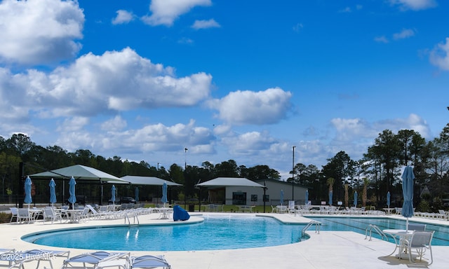 155 Abbington Pl SW, Ocean Isle Beach, NC 28469 - community pool with fence, a patio, and view of wooded area
