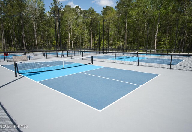 155 Abbington Pl SW, Ocean Isle Beach, NC 28469 - view of tennis court featuring a forest view and fence
