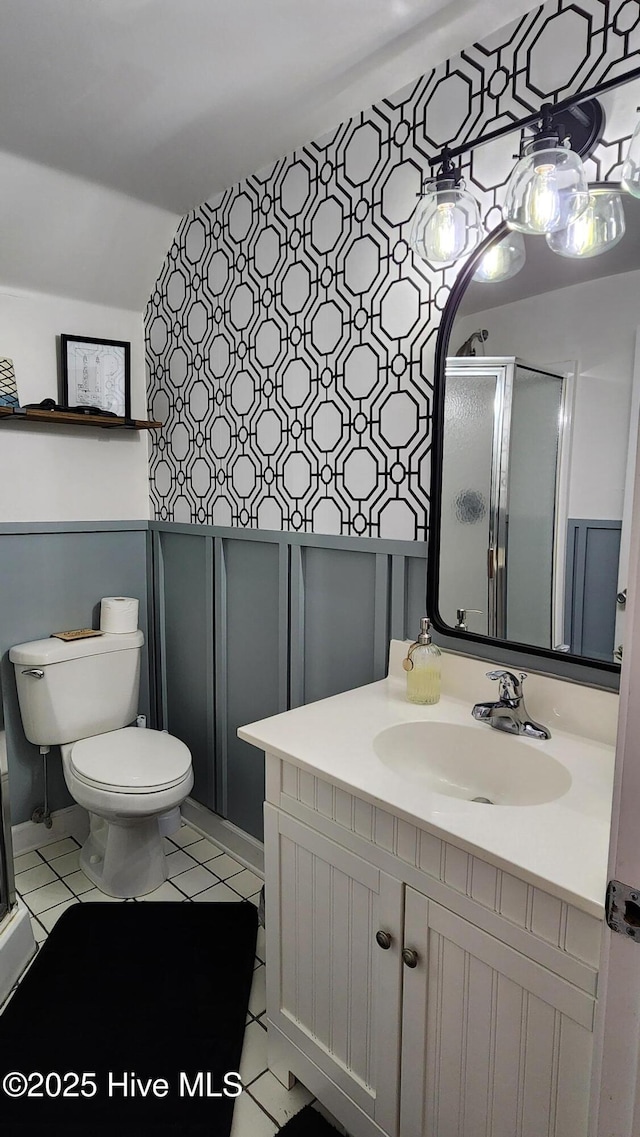 full bathroom with a shower stall, vanity, toilet, and tile patterned floors