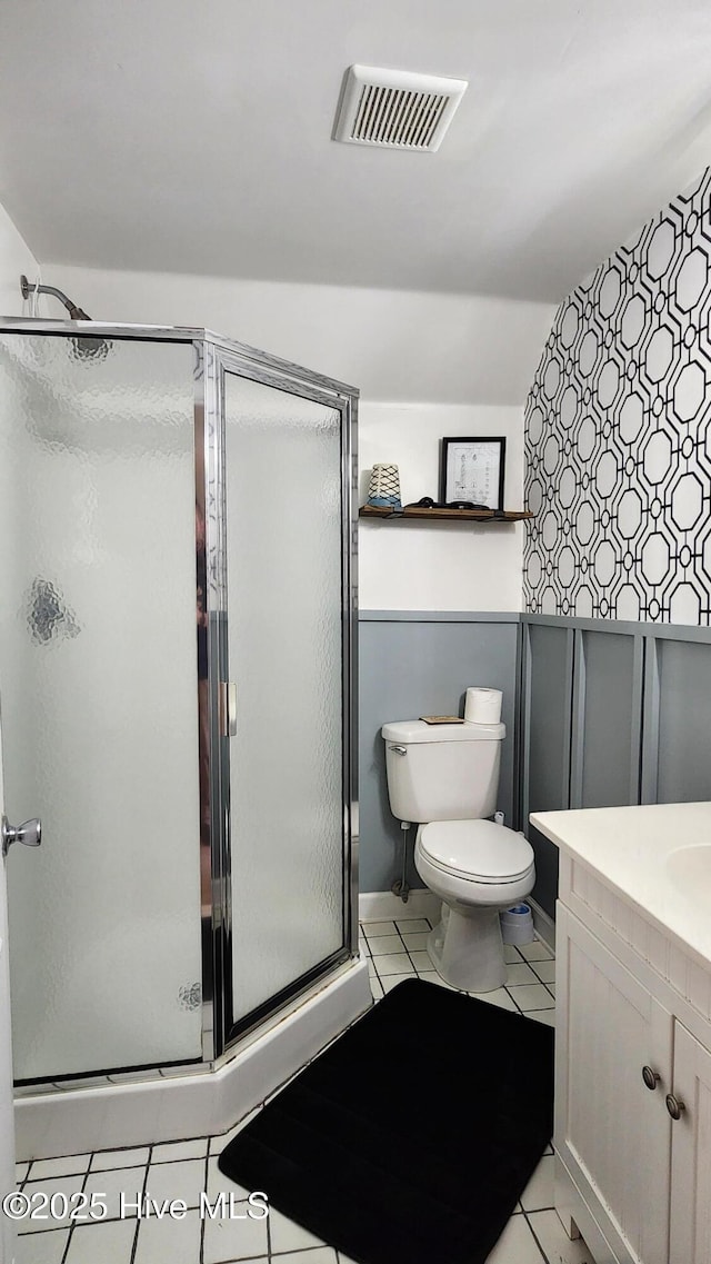 bathroom with toilet, vanity, visible vents, a shower stall, and tile patterned floors